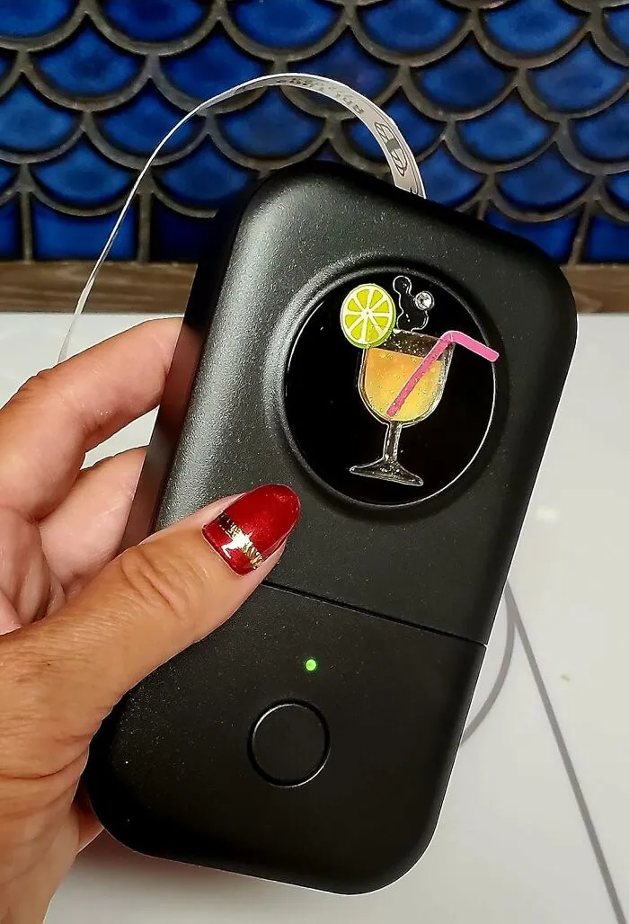 Hand holding a black portable device with a lemon drink sticker, one of the affordable finds on Amazon.