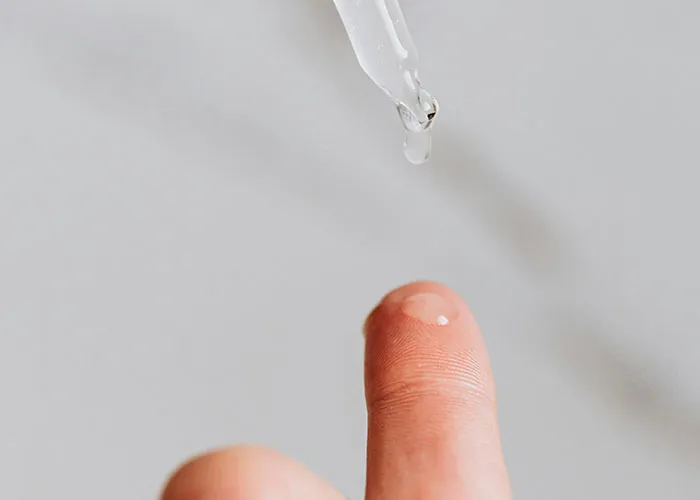 Close-up of a finger with a clear liquid droplet from a dropper, illustrating surprisingly entertaining facts shared online.