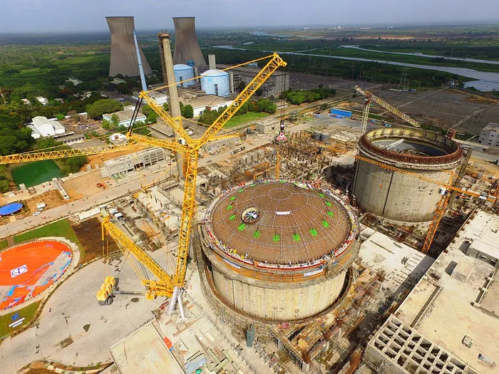 A large industrial construction site with cranes and workers revealing disturbing workplace secrets after quitting jobs.