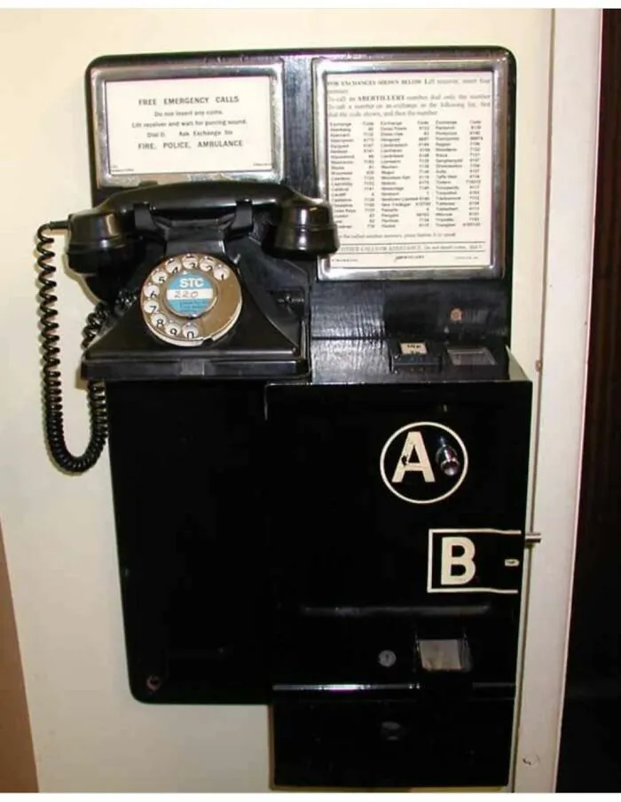Vintage rotary phone and coin-operated emergency call box, a strange thing found in homes with haunted pasts.