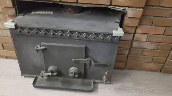 Old metal stove built into a brick wall, one of the strange things found in homes with hidden or haunted pasts.