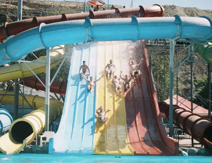 People sliding down colorful water slides at a water park, an experience many say never doing that again after thrill rides.