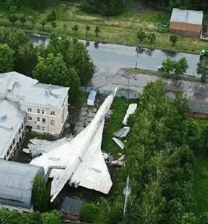 Avión abandonado entre árboles y edificios, uno de los lugares misteriosos encontrados en Google Earth desde el aire.