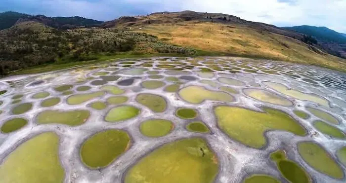 Lago Spotted, Canadá: Un lago que se evapora en verano, dejando pequeñas piscinas minerales de diferentes colores, creando un paisaje único.
