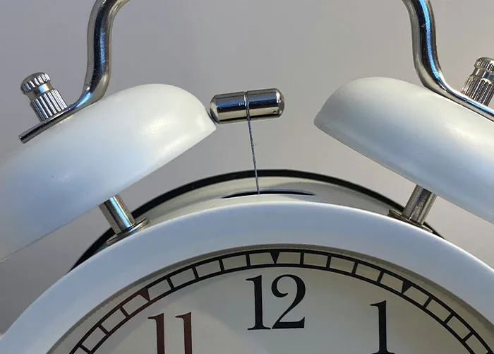 Close-up of broken white alarm clock bell, illustrating worst gifts people have ever received.