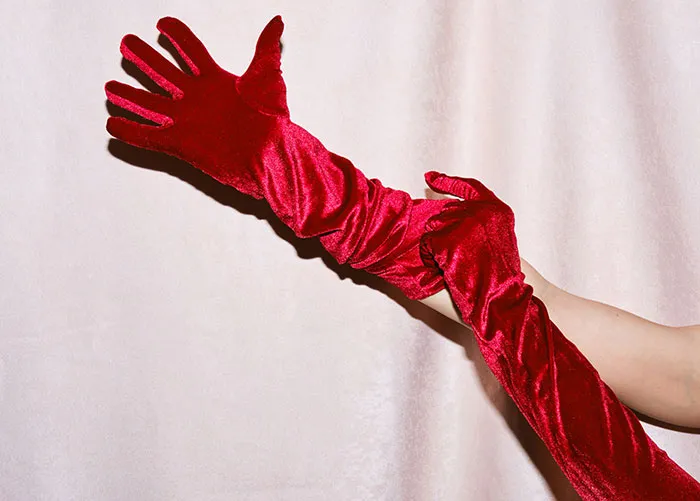 Person wearing long red velvet gloves reaching out, illustrating some of the worst gifts ever received.