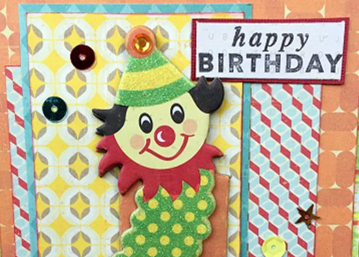 Colorful handmade birthday card with a smiling clown decoration and sequins, related to worst gifts shared by people.