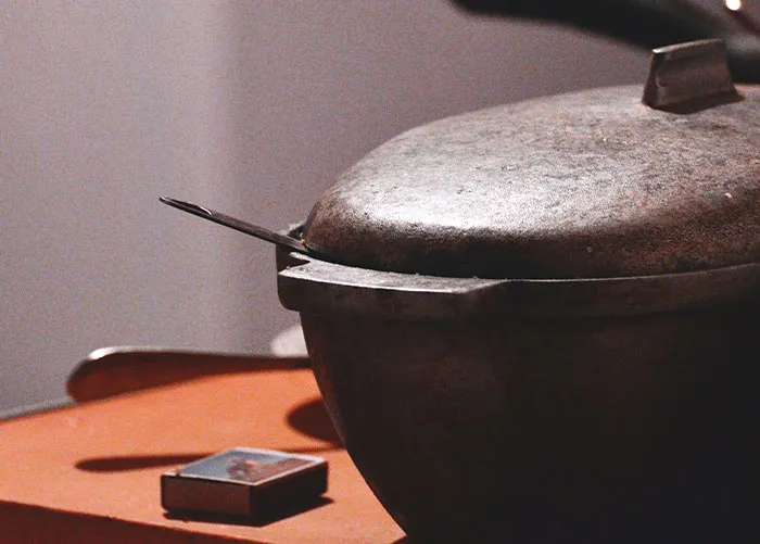 Old, rusty cooking pot on a table with a small box nearby, illustrating worst gifts received by people.