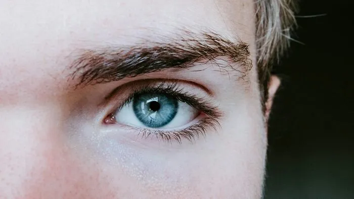 Close-up of a blue eye showcasing unique features, illustrating the impact of good or bad genes on appearance.