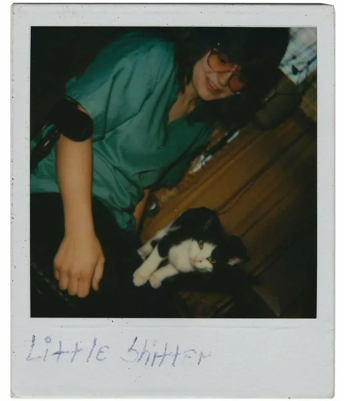 Vintage photo of a woman wearing glasses with a black and white cat, showcasing interesting and mesmerizing history moments.