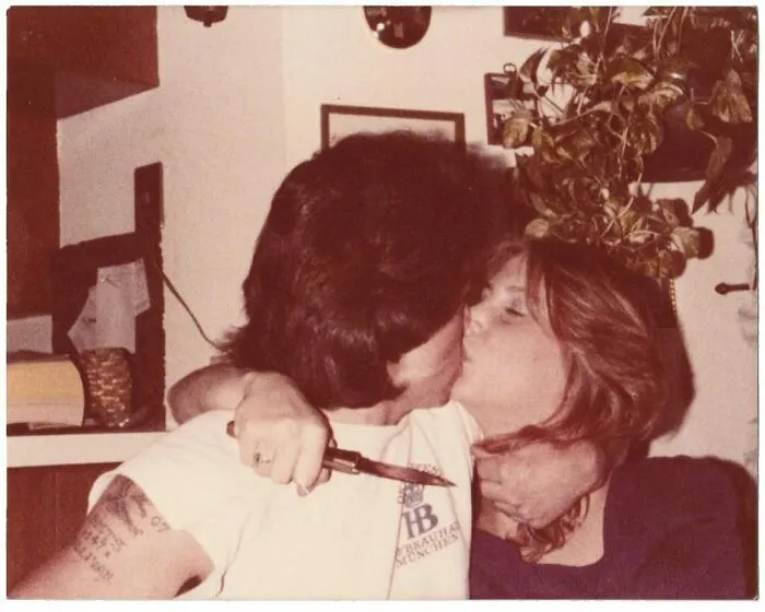 Vintage photo of a couple kissing passionately indoors, capturing an intimate moment from history.