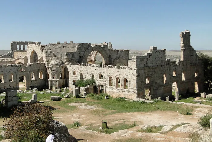 Ancient UNESCO treasure ruins under clear sky with stone arches and weathered walls in open landscape.