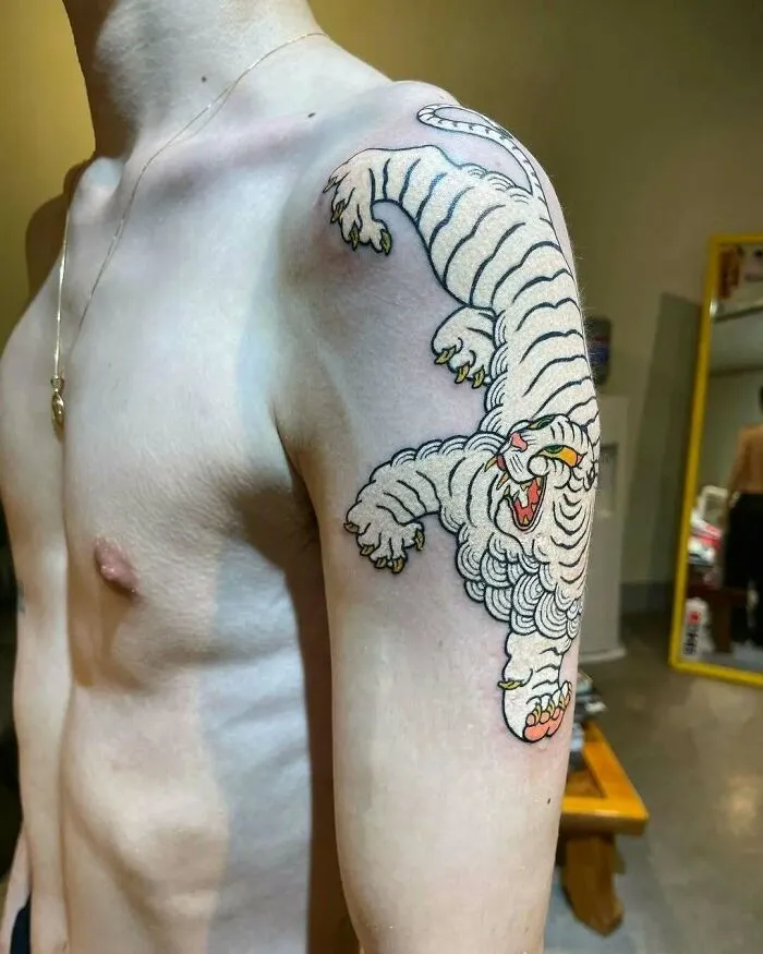 Tatuaje de tigre blanco en el brazo de una persona, ejemplo de tatuajes que van desde lo gracioso hasta lo terrible.