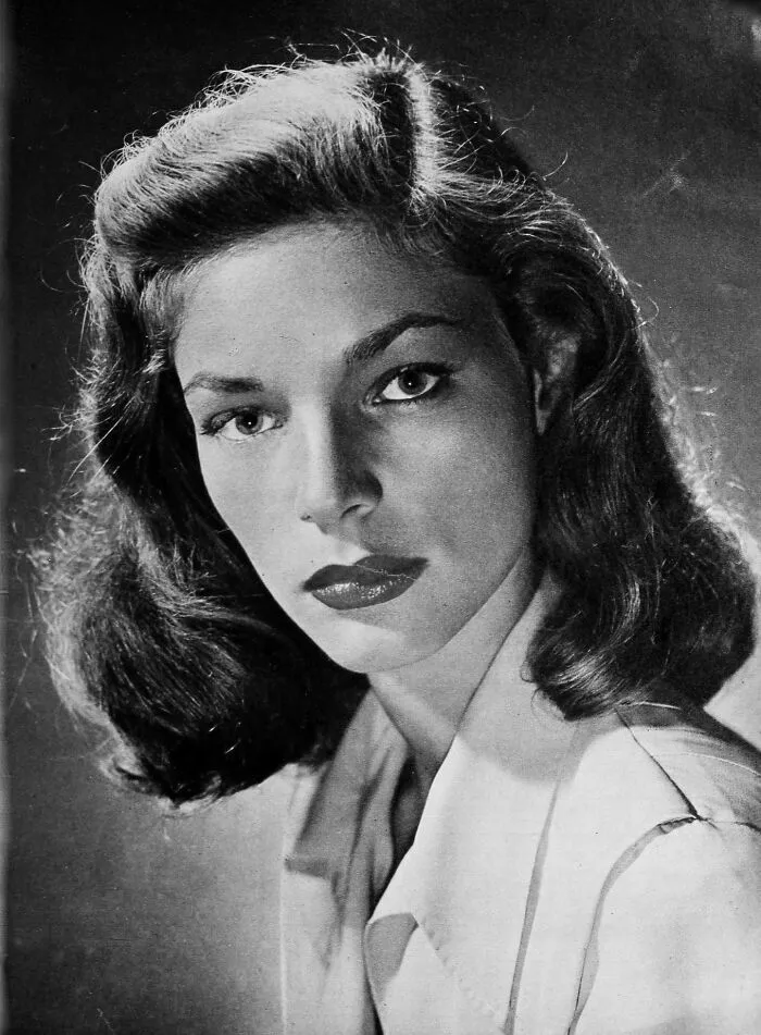 Black and white portrait of a glamorous 1940s icon with styled hair and classic makeup in Hollywood golden era.