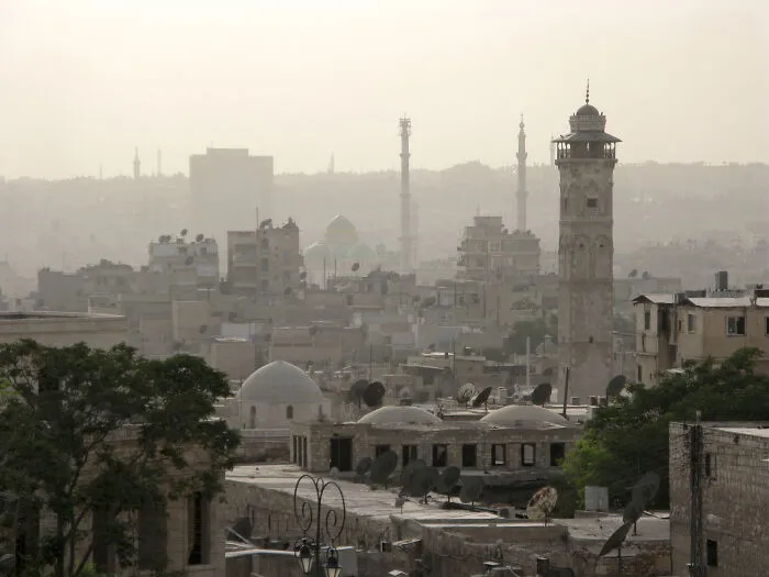 Ancient cityscape with historic buildings and a tall tower representing stunning UNESCO treasures in a hazy atmosphere.