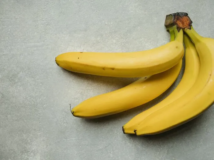 Ripe bananas on a gray surface illustrating food prices comparisons in the 1980s and now.
