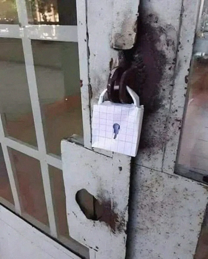 Old rusty door secured with a padlock wrapped in grid paper, a weird pic or it didn’t happen moment from a Facebook group.