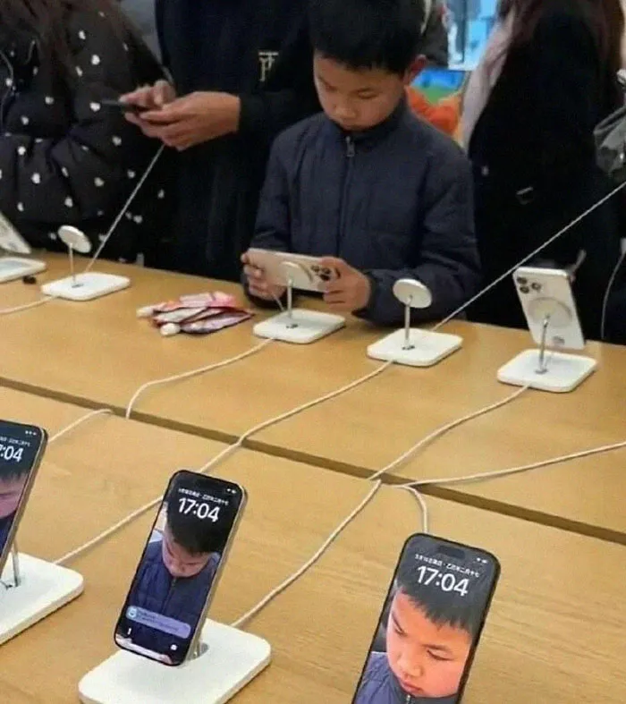 Young boy taking a photo in a tech store with phones showing mirrored weird pics or it didn’t happen moments on display.