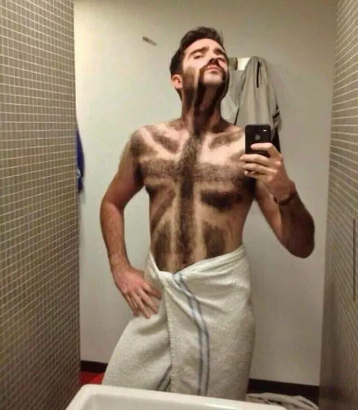 Man with weird chest hair patterns posing in a bathroom mirror selfie, illustrating weird pics or it didn’t happen moments