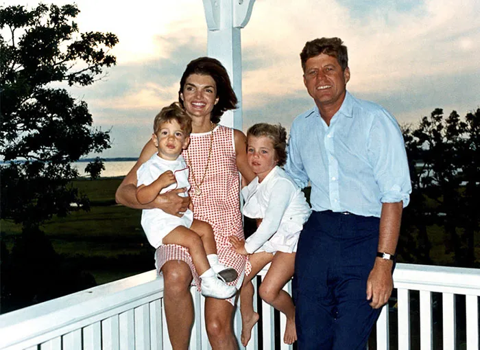 John F. Kennedy with family outdoors at sunset, representing famous celebrities remembered differently after passing.