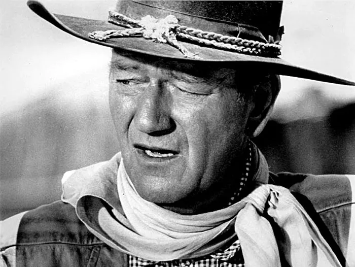 Black and white portrait of a man in a cowboy hat and scarf, representing celebrities praised after passing, including Steve Jobs.