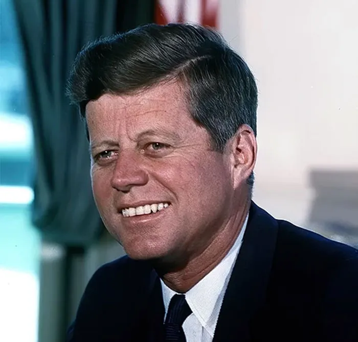 Portrait of a smiling man in a suit and tie, highlighting celebrities who were praised after their passing.