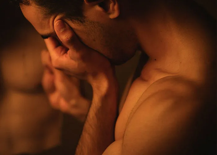 Man with hands covering face in emotional distress, symbolizing pain of discovering cheating partners and betrayal.