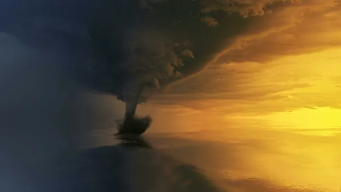 A dramatic tornado forming over water during sunset, illustrating mind-boggling natural phenomena and beliefs.