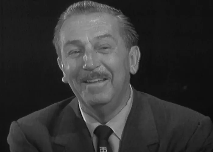 Black and white portrait of a man smiling, relating to people who knew celebrities before fame revealing their stories.