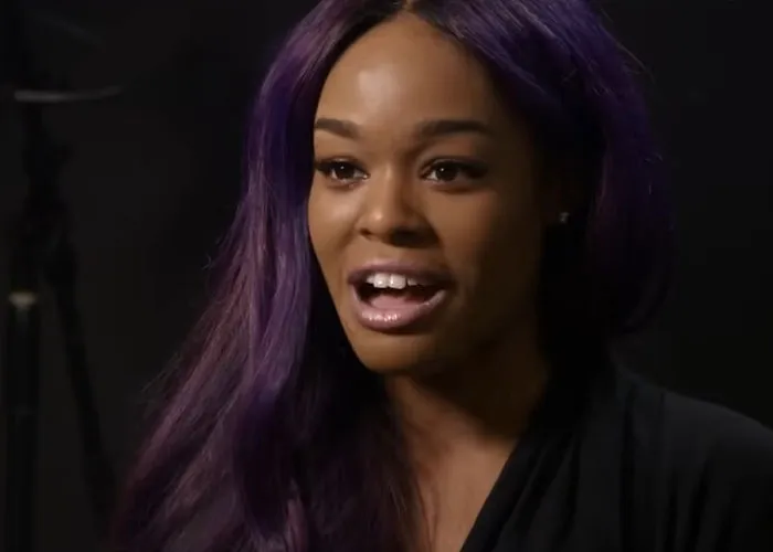 Woman with long purple hair speaking in an interview about people who knew celebrities before fame and their true personalities.