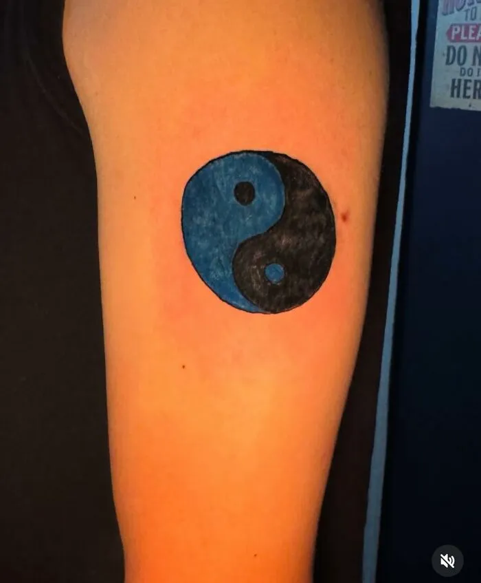 Tattoo of a yin-yang symbol on arm with incorrect colors, showcasing a hilariously bad tattoo mistake inkshaming.