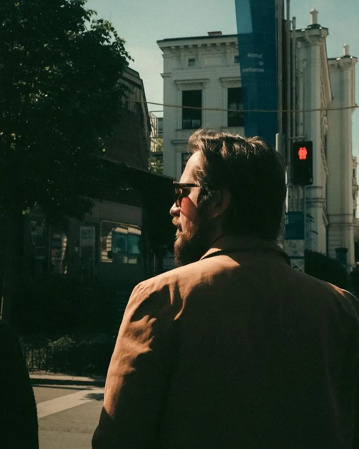 Man in sunglasses captured in an urban photo by a Helsinki-based photographer in a real street moment.
