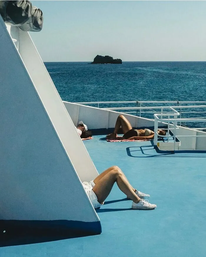 People relaxing on a boat under the sun, captured in an urban photo that looks like a movie still but is a real moment.