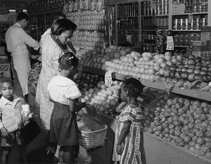 Surplus Fruit Goes Into The Market Basket Of A Memphis, Tennessee Housewife Who Is Exchanging Her Surplus Food Stamps For Food For Her Family, 1940