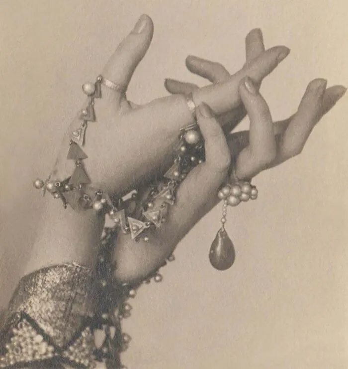Vintage photo of hands adorned with intricate jewelry, capturing a mesmerizing moment rich in historical detail.