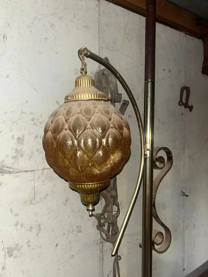 Vintage decorative hanging lamp with ornate design discovered among unexpected things found in walls and hidden places in homes.