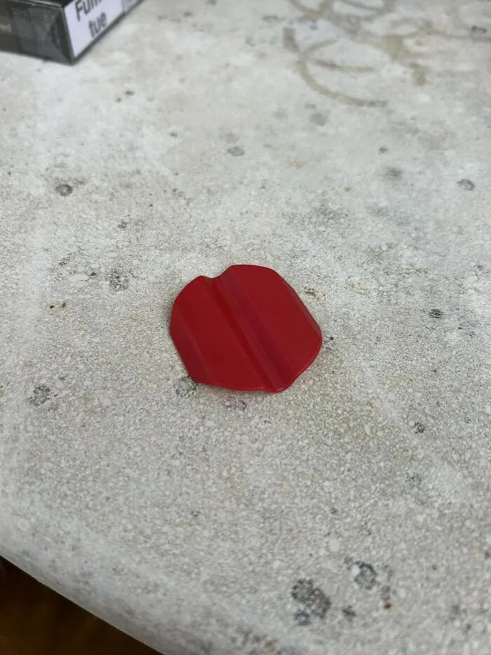 Red plastic mystery object with a central ridge, featured in an online group recognizing unknown mystery objects.