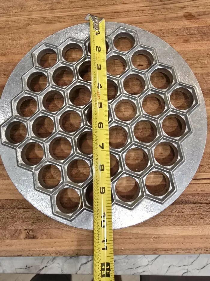 ¿Qué es esto?: Una placa grande de aluminio con patas y pequeños agujeros hexagonales.