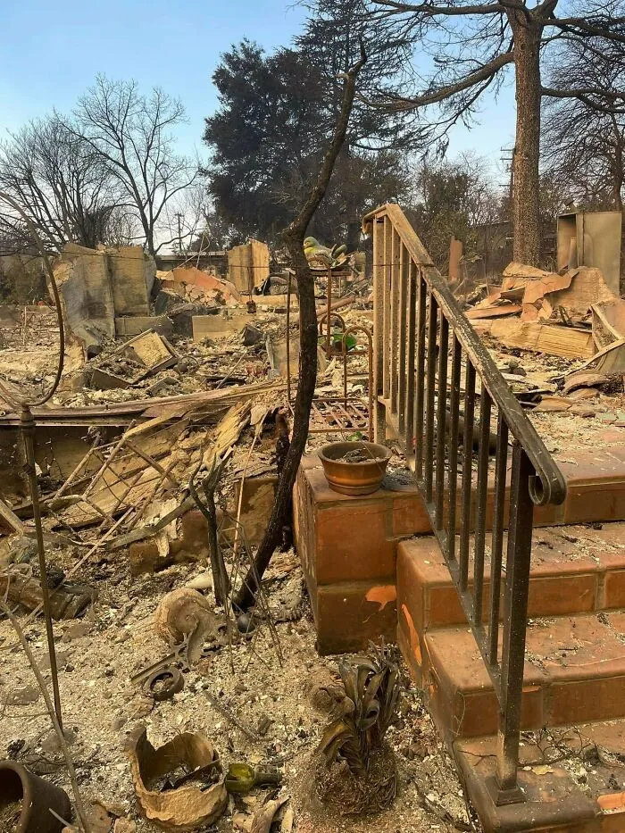 Burned remnants of a destroyed home with debris and ash covering the ground in a disturbing scene from new photos.
