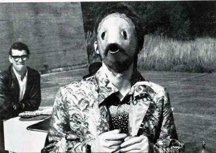 Disturbing photo of a person wearing a creepy mask and patterned jacket, evoking eerie and unsettling feelings.