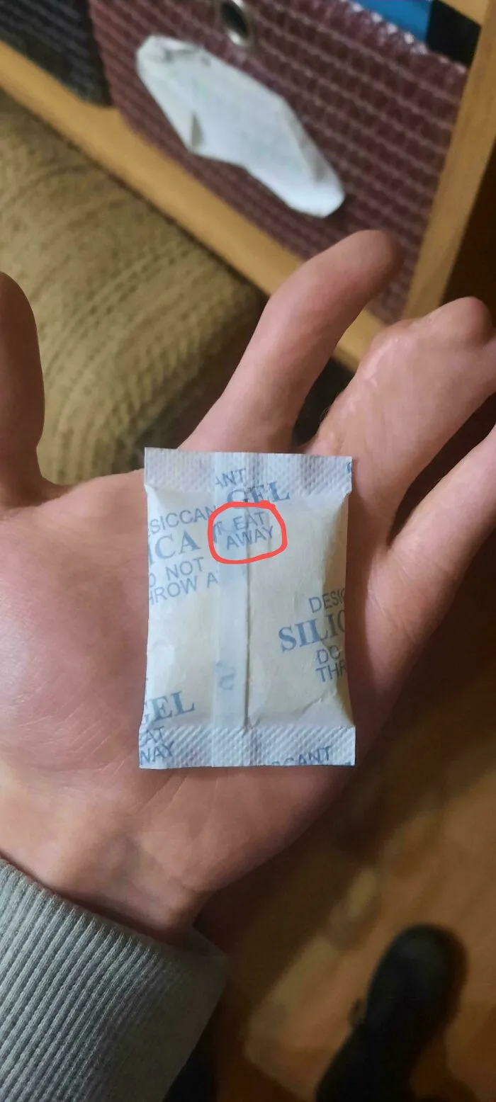 Silica gel packet humorously labeled with contradictory eat away warning in a funny pic showing confusion.