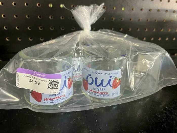 Ridiculous thrift store find of glass yogurt containers, still packaged, priced at $4.99 in a plastic bag on a store shelf.