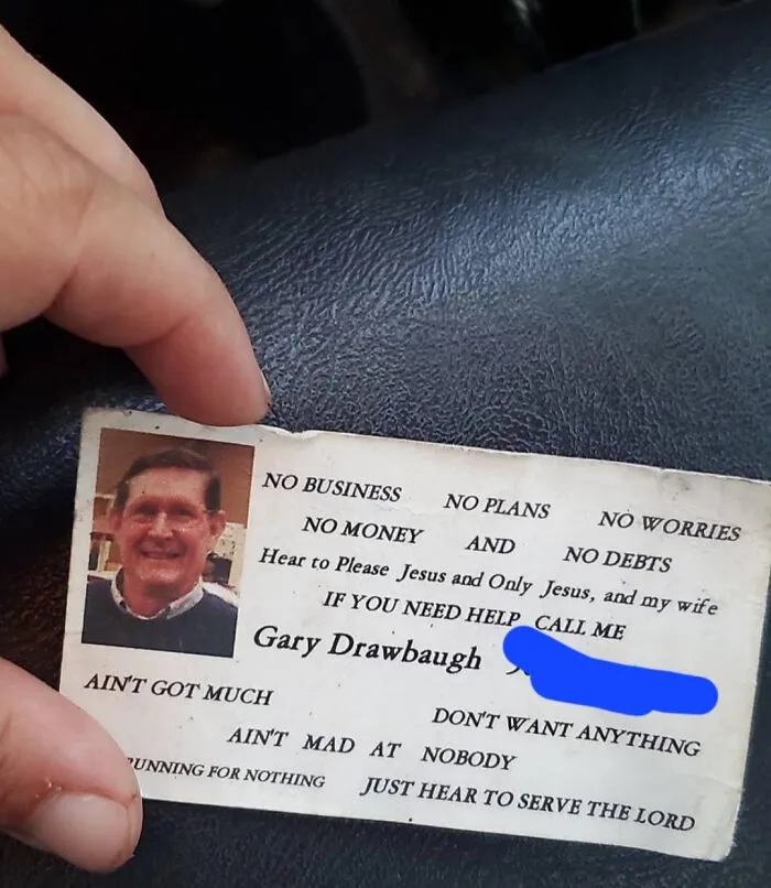 Hand holding a vintage business card featuring an old photo and a heartfelt message, a historical memento found randomly.