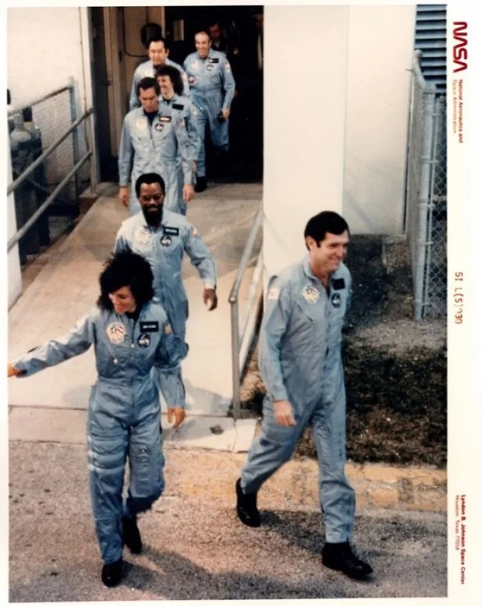 Crew Members Of STS 51-L Mission Walk Out Of The Operations And Checkout Building At Kennedy Space Center, On Their Way To Pad 39b Where They Will Board The Space Shuttle Challenger