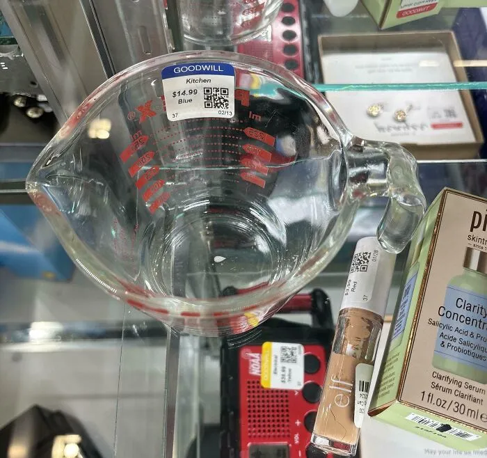 Clear glass measuring cup with a price tag at a thrift store, showcasing ridiculous finds shared by people online.
