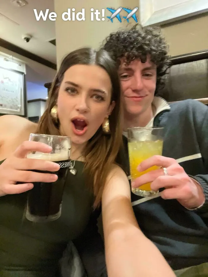 Two people celebrating with drinks, capturing a joyful moment after overcoming fear of flying and boarding a plane.