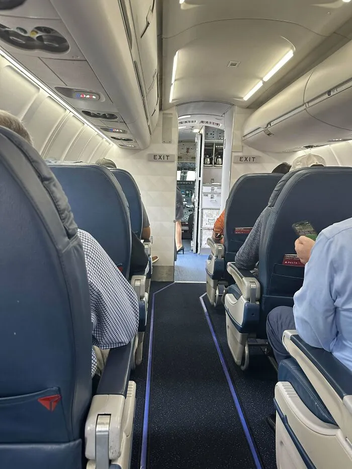 Interior view of a plane cabin with passengers seated, highlighting moments of overcoming fear of flying on board.