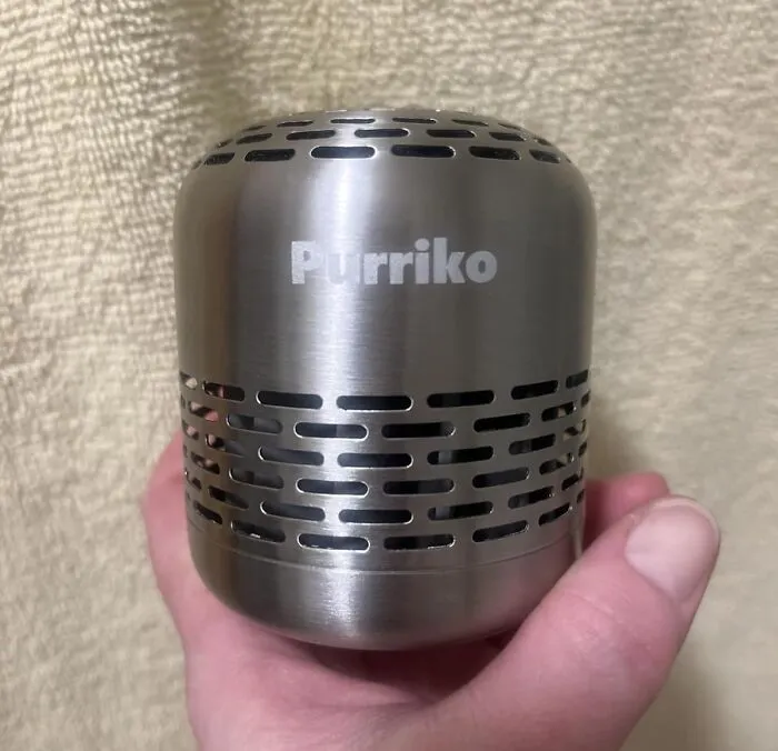 Hand holding a small metal device labeled Purriko, featured as a trending product in the Pandaverse virtual market.