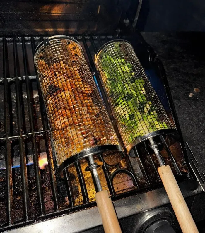 Mesh grilling baskets with wooden handles cooking vegetables and meat on a barbecue grill trending pandaverse products.