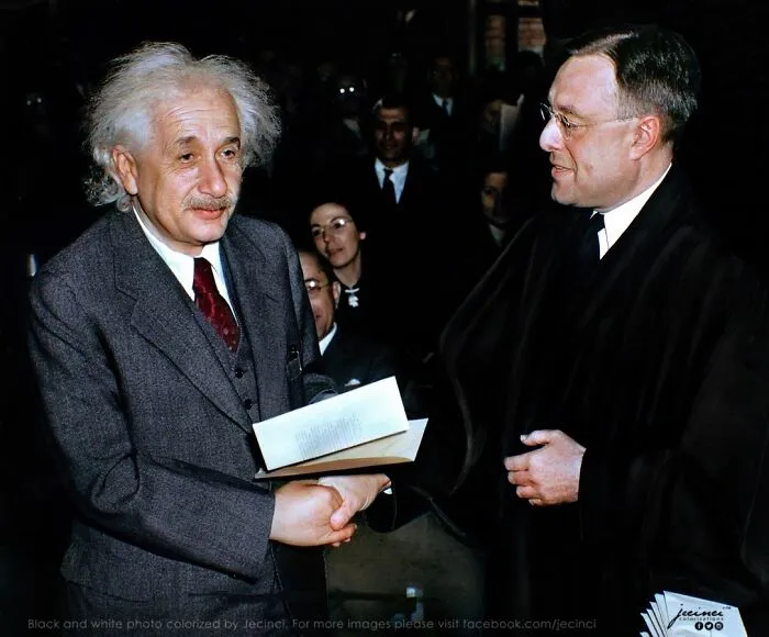 Albert Einstein shaking hands with a man during an event in an interesting colorized history pic.